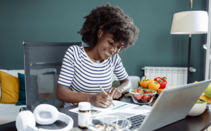 Lady at her kitchen table creating a meal plan.