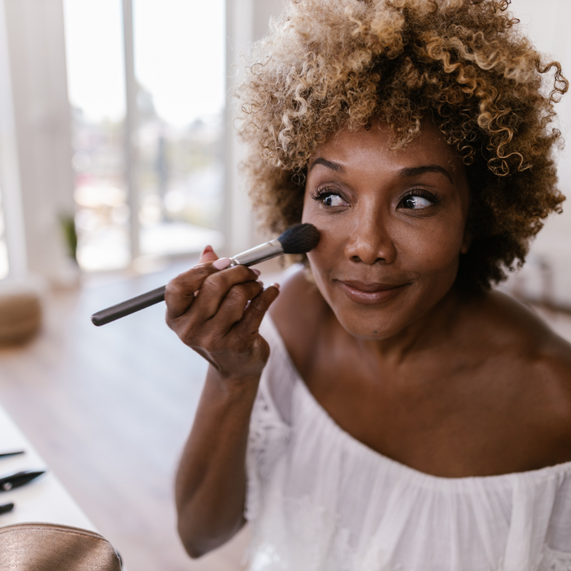 Black woman 40+ applying makeup that may be toxic